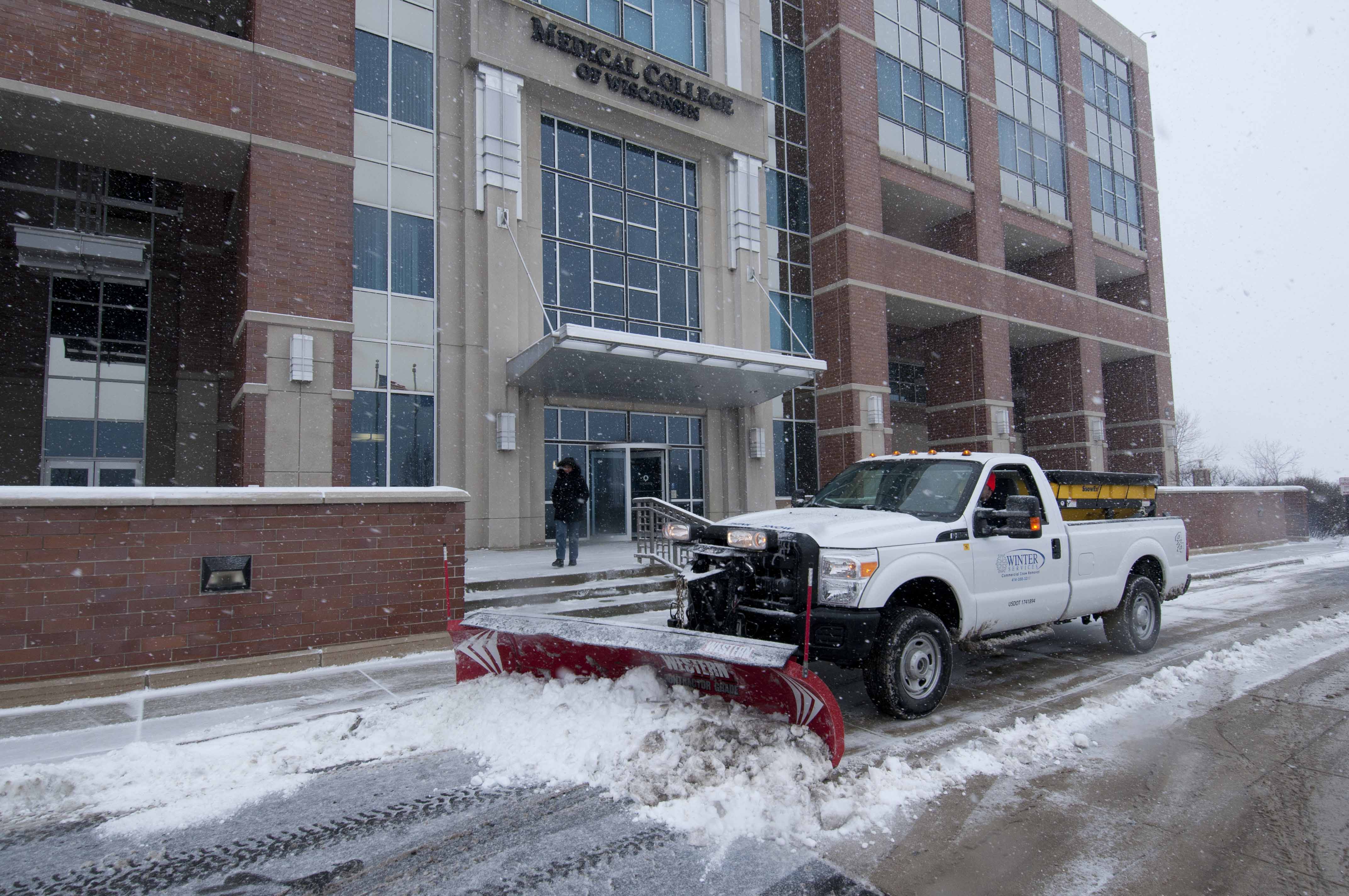 Commercial snow plow clearing a parking lot